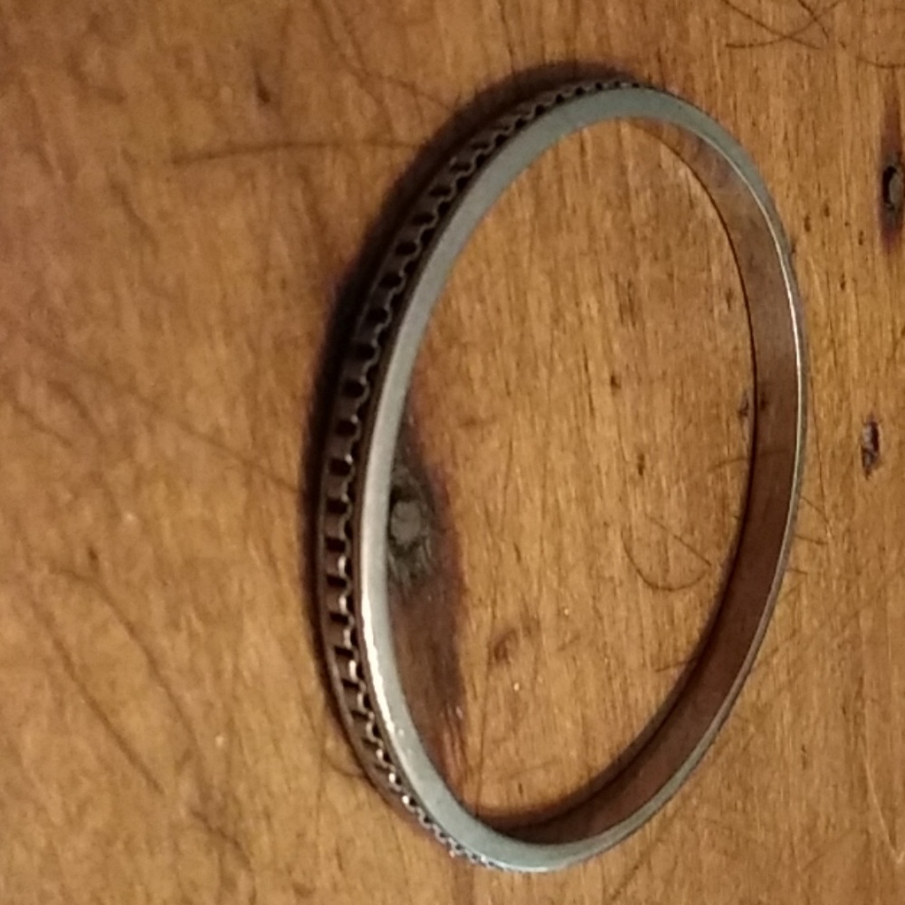 Silver tone bracelet with design on front